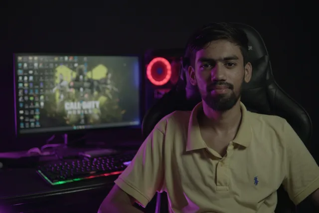 A bearded man sitting at a computer setup with a gaming PC and chair, creating a moody ambiance. Building a gaming advertising campaign review